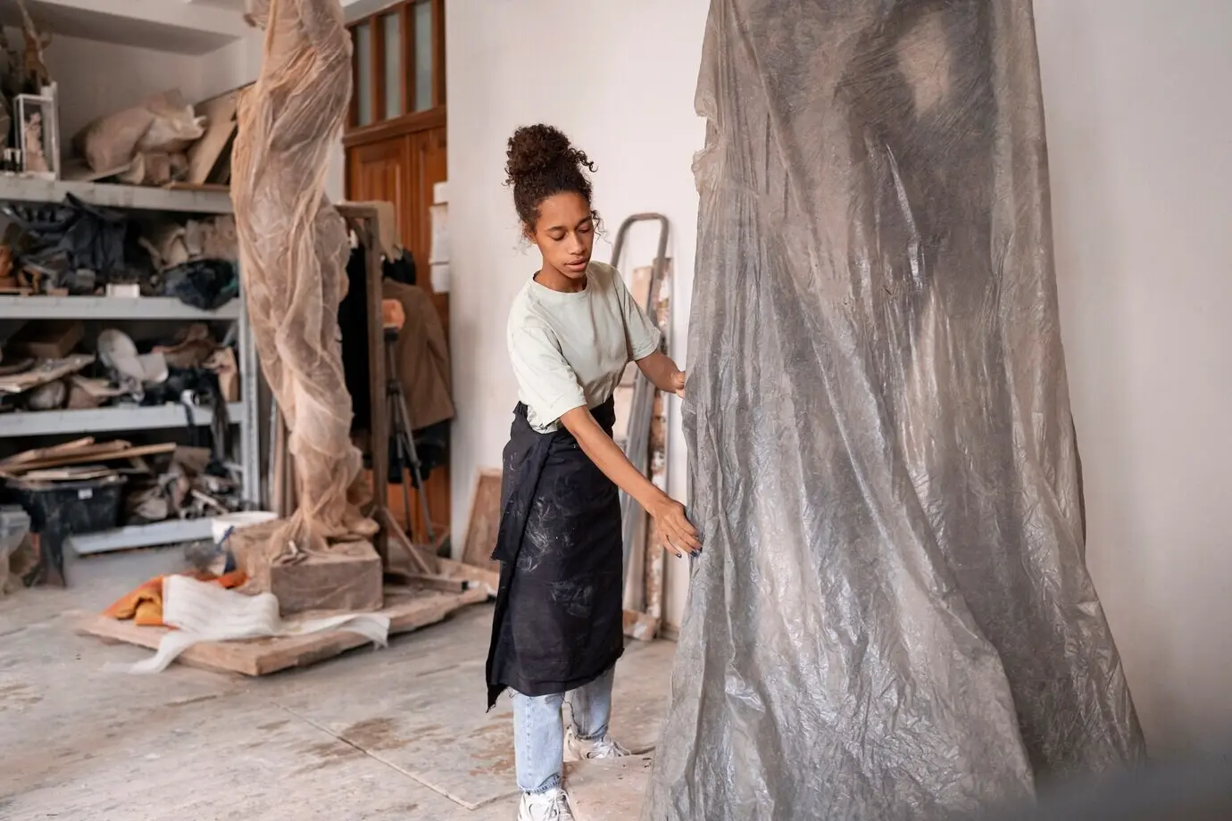 Frau beim Modellieren von Ton, Ganzkörperaufnahme